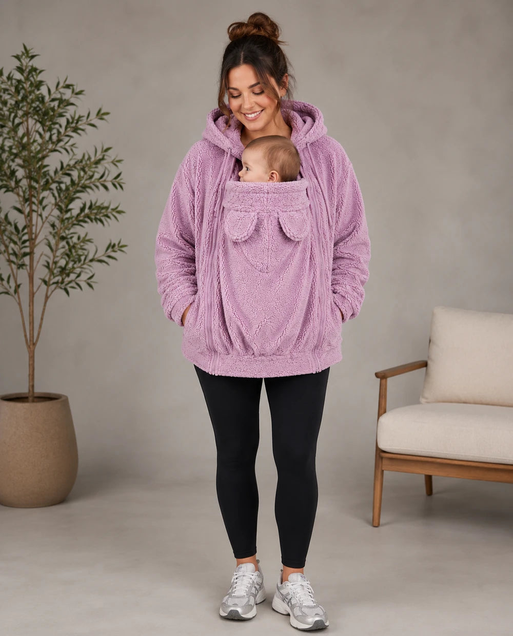 Mother wearing the pink Everlittle SnuggleNest babywearing fleece hoodie with baby